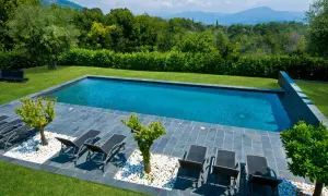 Piscine prête pour la saison. Remise en route piscine après hivernage actif, avec transats et vue sur les montagnes.