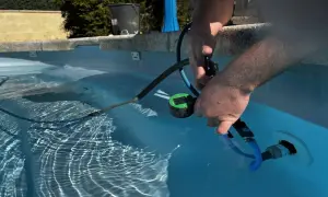 Un homme utilise un appareil pour localiser une fuite dans sa piscine.