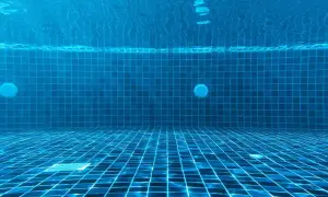 Vue sous-marine d'une piscine carrelée de bleu. La lumière du soleil filtre à travers l'eau. Question : chlore choc combien de temps faire tourner la pompe ?