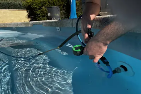 Un homme utilise un appareil pour localiser une fuite dans sa piscine.