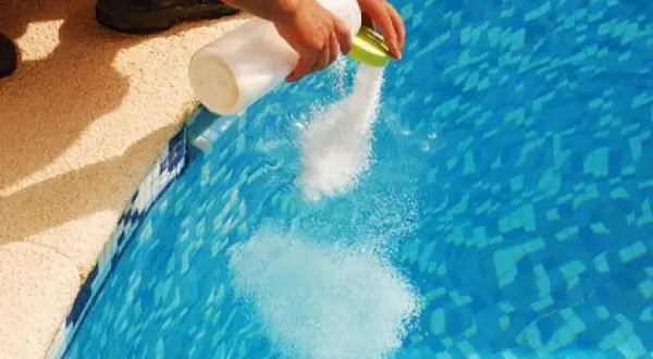 Ajout de sel dans une piscine pour éviter la conséquence du manque de sel piscine. L'eau devient plus claire.