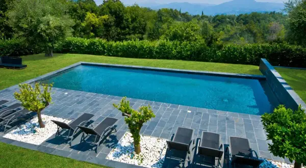 Piscine prête pour la saison. Remise en route piscine après hivernage actif, avec transats et vue sur les montagnes.