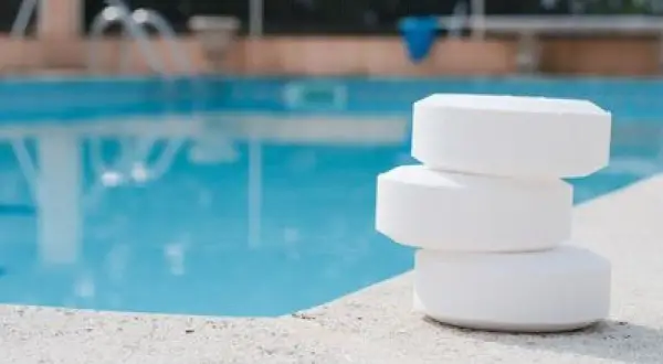 Trois pastilles de chlore empilées sur le bord d'une piscine. Le stabilisateur ppm est trop bas, il faut agir vite !