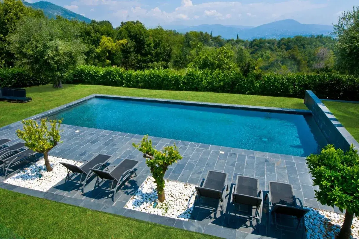 Piscine prête pour la saison. Remise en route piscine après hivernage actif, avec transats et vue sur les montagnes.