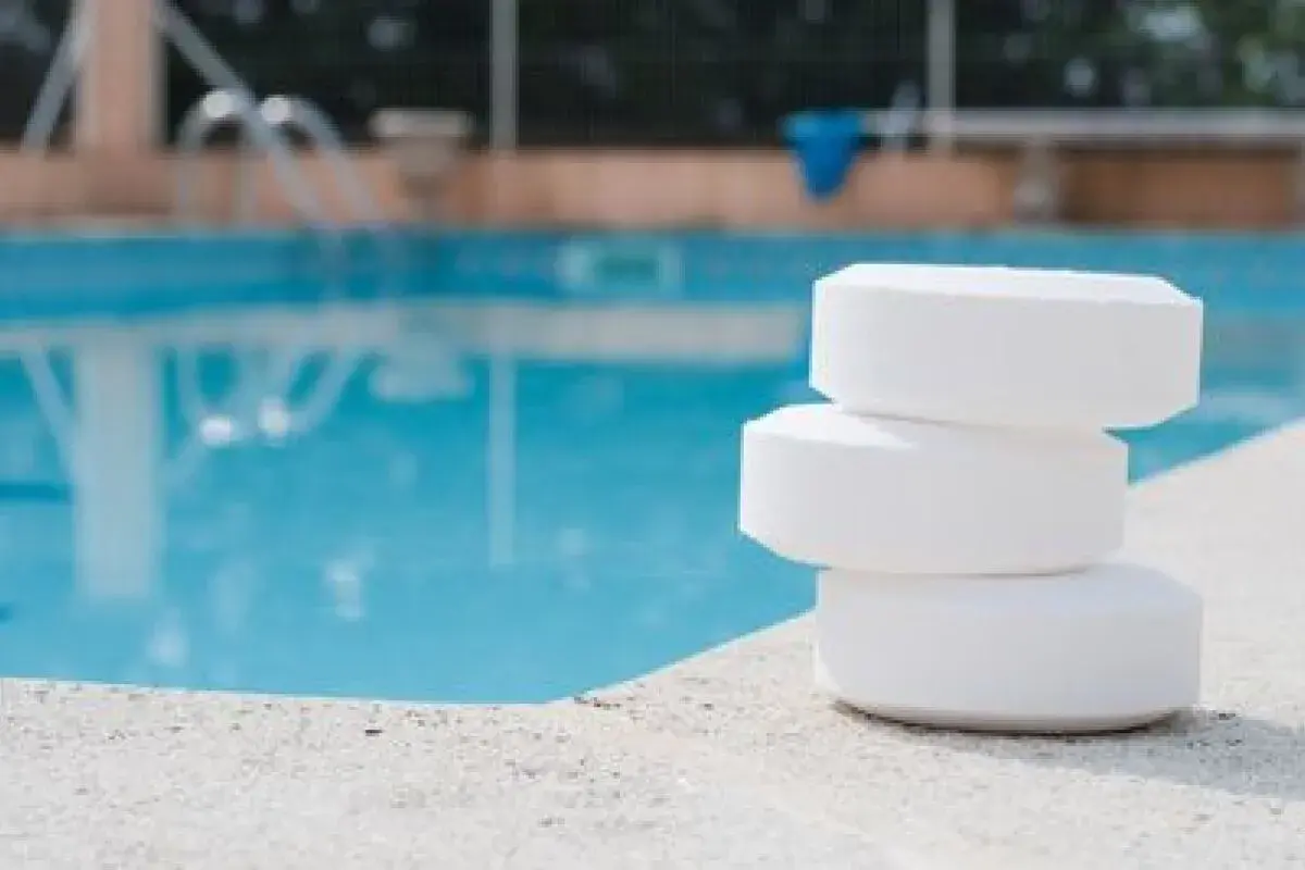 Trois pastilles de chlore empilées sur le bord d'une piscine. Le stabilisateur ppm est trop bas, il faut agir vite !