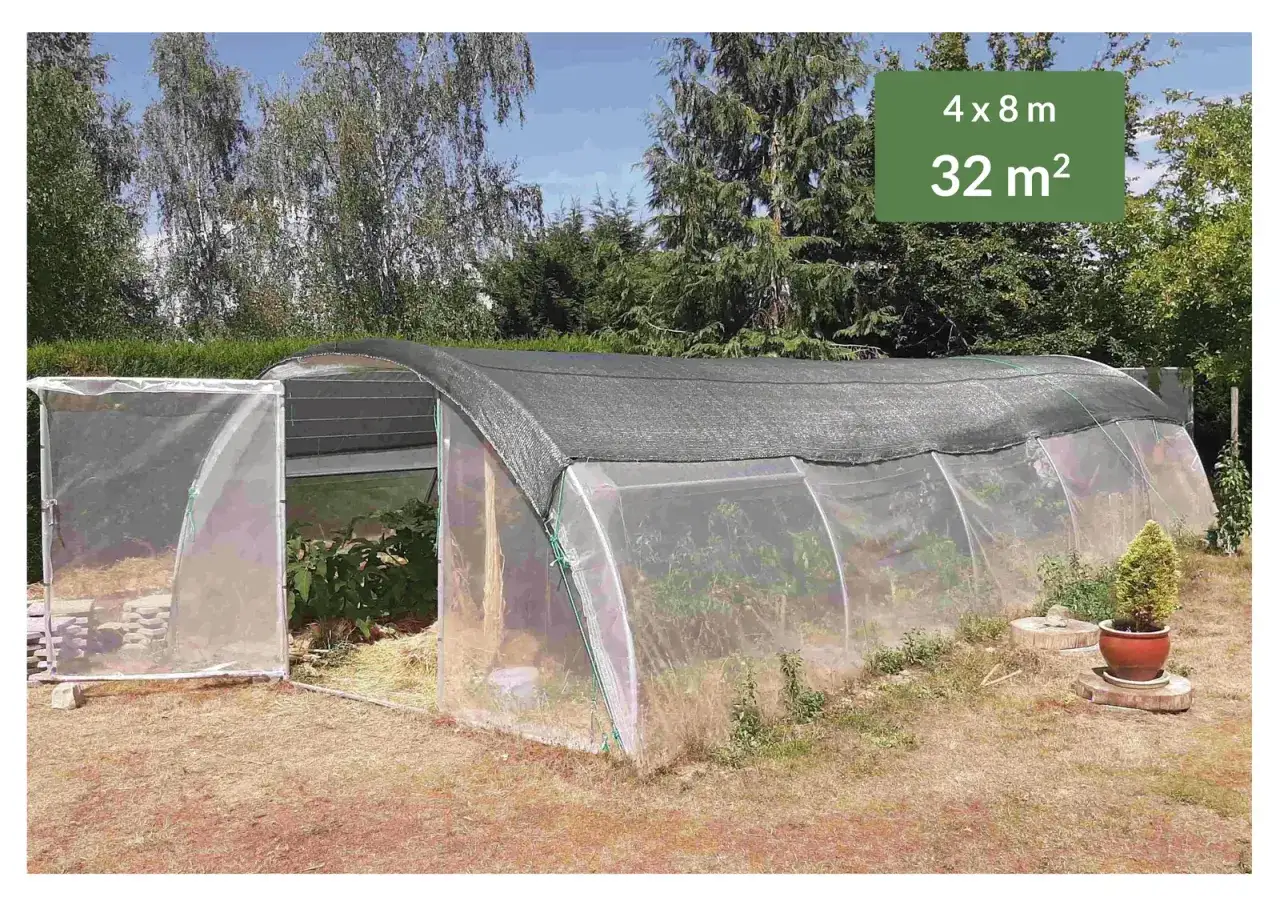 Serre tunnel de 32 m² avec porte ouverte, idéale pour la culture sous serre de légumes et plantes.