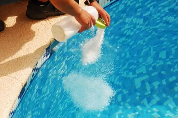 Ajout de sel dans une piscine pour éviter la conséquence du manque de sel piscine. L'eau devient plus claire.