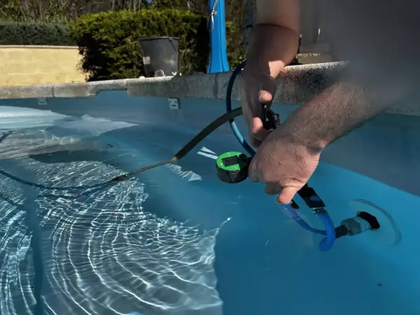 Un homme utilise un appareil pour localiser une fuite dans sa piscine.