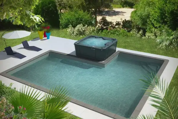 Un spa intégré à une piscine, entouré de verdure et de chaises longues. Parfait pour se détendre au soleil.